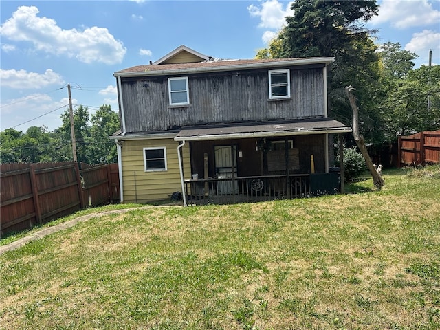 rear view of property with a lawn