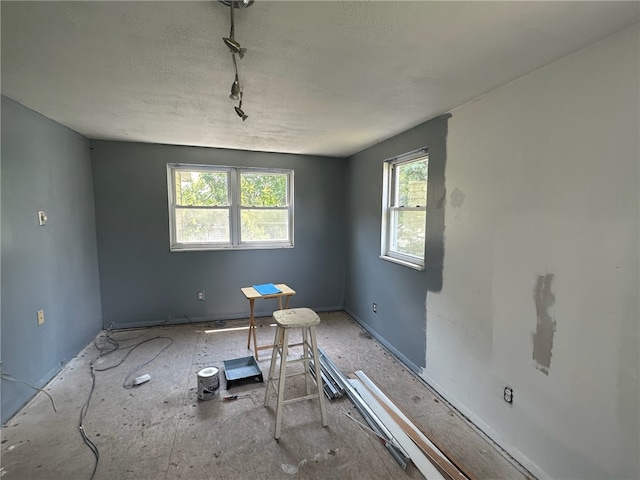 empty room featuring a wealth of natural light and a textured ceiling