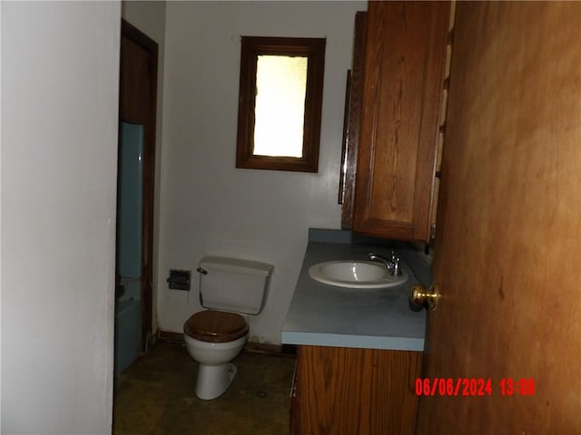 bathroom featuring vanity, toilet, and a washtub