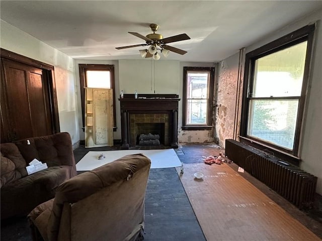 living room featuring a tile fireplace and ceiling fan