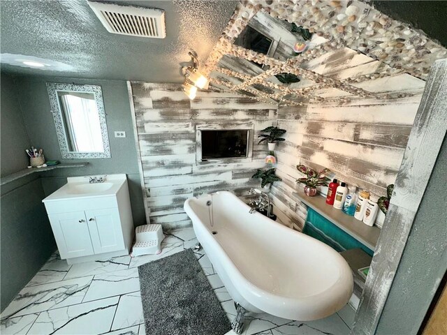 bathroom with tile flooring, wooden walls, a textured ceiling, and large vanity