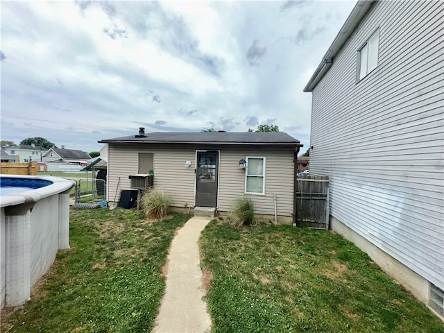 rear view of property featuring a lawn