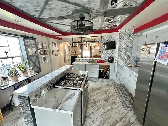 kitchen featuring appliances with stainless steel finishes, a center island, tasteful backsplash, and light hardwood / wood-style flooring