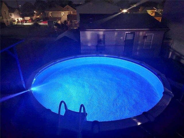 pool at night with a patio area