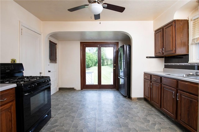 kitchen with sink, ceiling fan, refrigerator, tasteful backsplash, and black range with gas stovetop