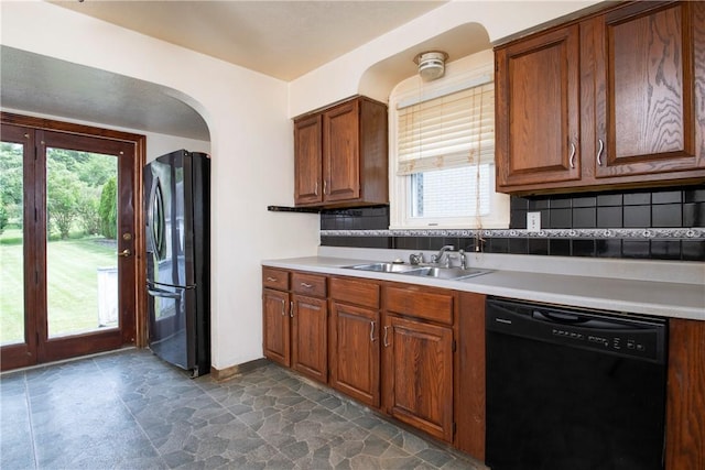 kitchen featuring refrigerator, dishwasher, sink, and backsplash