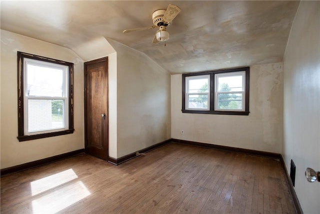 additional living space featuring lofted ceiling, hardwood / wood-style floors, and a healthy amount of sunlight