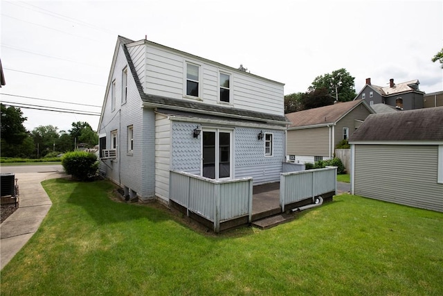 rear view of property featuring cooling unit and a lawn