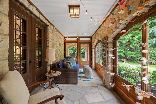 sunroom / solarium featuring french doors and rail lighting