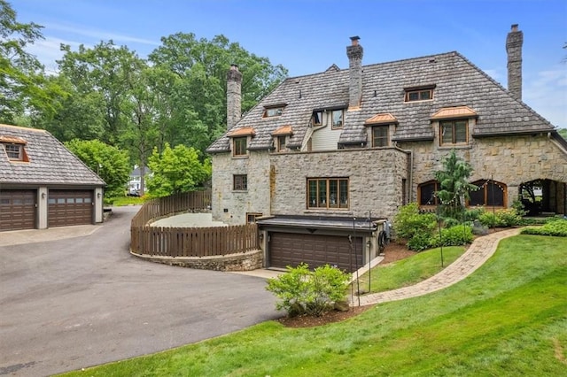 rear view of house with a garage and a yard