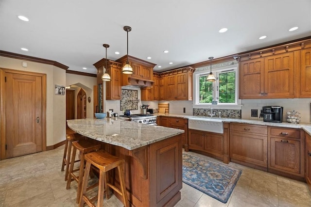 kitchen with hanging light fixtures, sink, range, and a kitchen bar