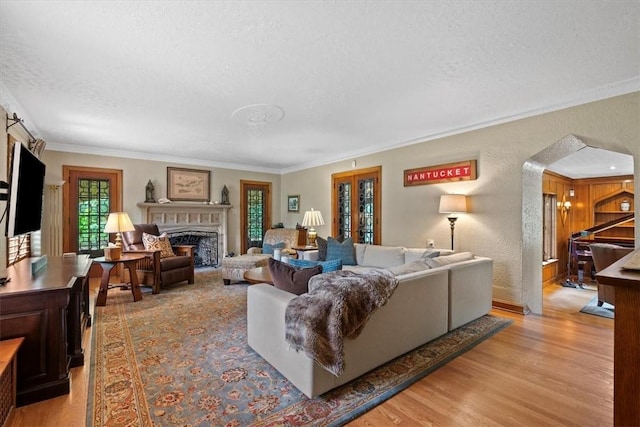 living room with crown molding, light hardwood / wood-style flooring, and a textured ceiling