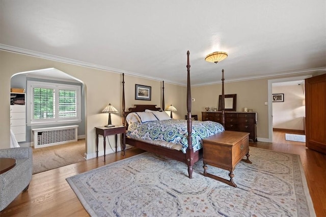 bedroom featuring ornamental molding, wood-type flooring, and radiator