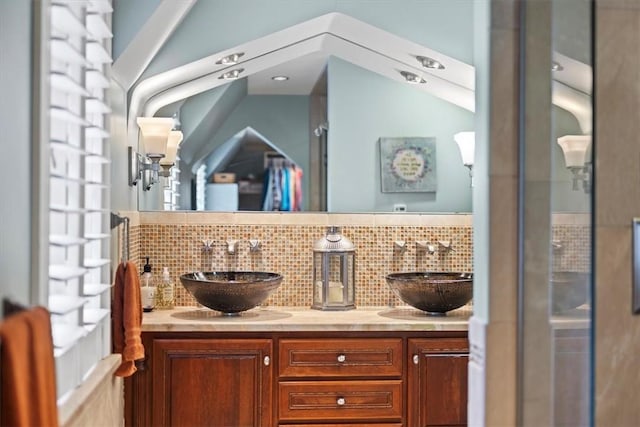 bathroom with vanity, a shower with shower door, and backsplash