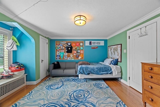 bedroom featuring crown molding and light wood-type flooring