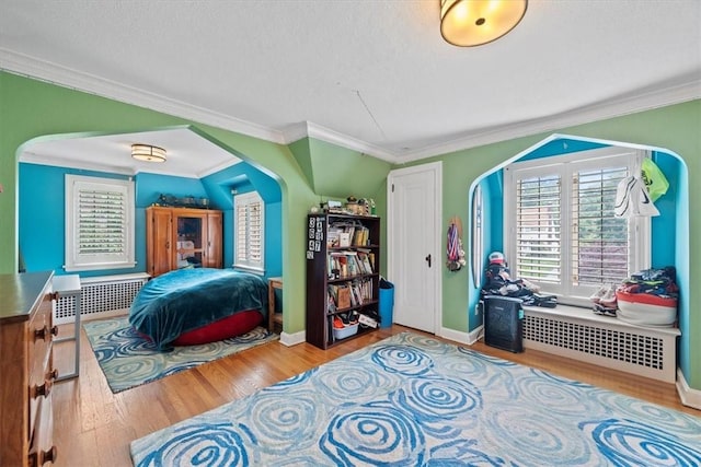 bedroom featuring crown molding, radiator heating unit, hardwood / wood-style floors, and a textured ceiling