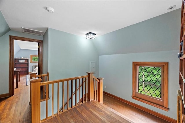 staircase with wood-type flooring and lofted ceiling