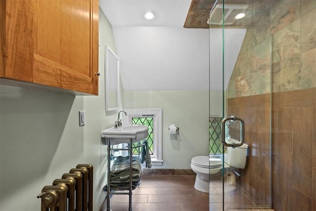 bathroom featuring toilet, a shower with shower door, sink, radiator, and tile patterned flooring