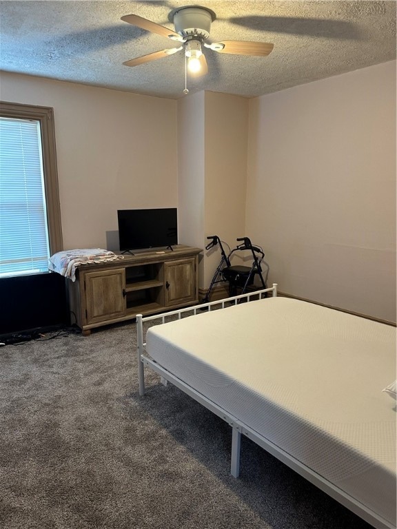 bedroom with carpet, ceiling fan, and a textured ceiling