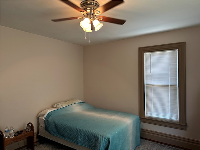 bedroom with ceiling fan and dark carpet