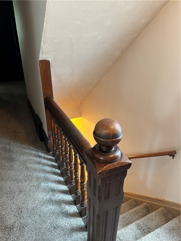 stairway featuring carpet and a textured ceiling