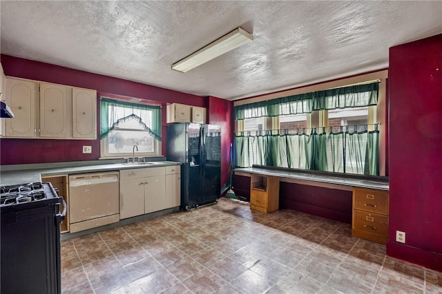 kitchen with a textured ceiling, sink, and black appliances