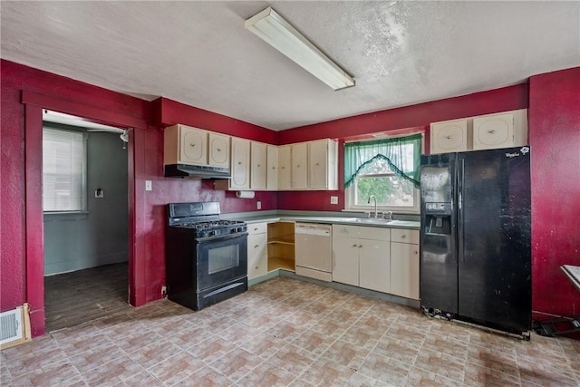 kitchen with a textured ceiling, sink, cream cabinets, and black appliances