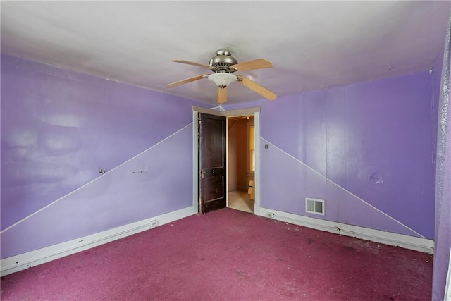 carpeted spare room featuring ceiling fan