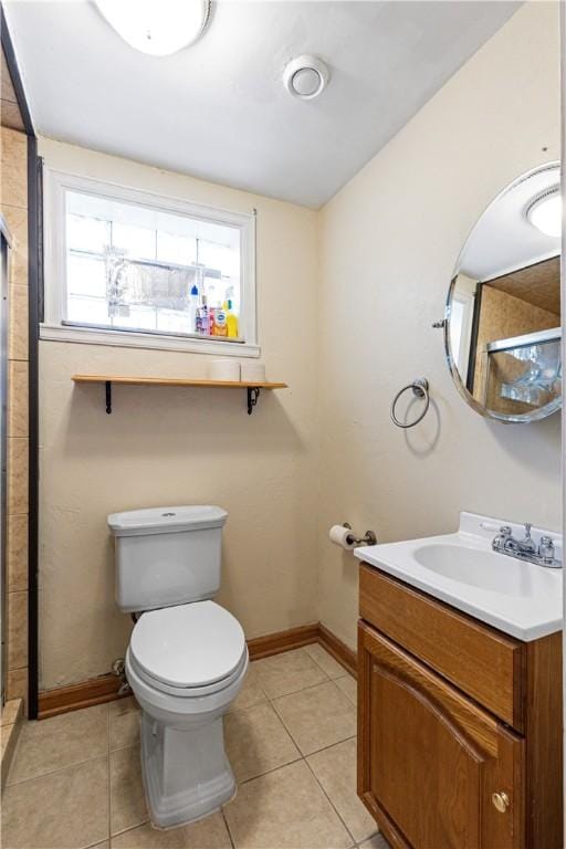 bathroom featuring tile patterned floors, vanity, toilet, and an enclosed shower