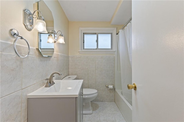 full bathroom with vanity, toilet, tile walls, and shower / tub combo