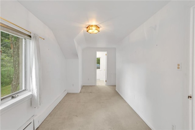 hallway with light carpet and lofted ceiling