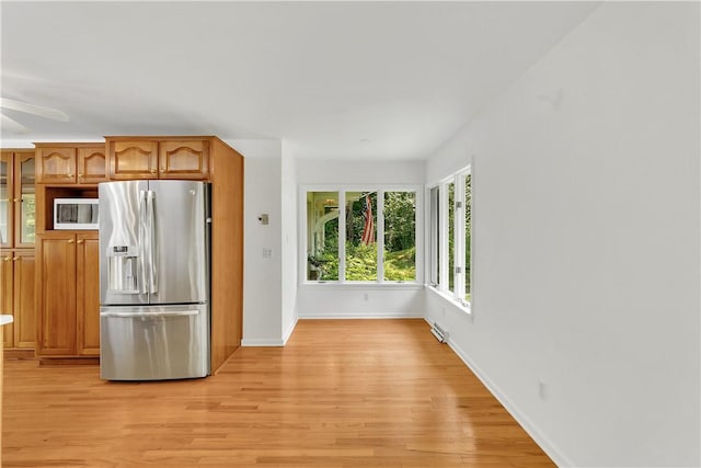 kitchen featuring ceiling fan, stainless steel refrigerator with ice dispenser, and light wood-type flooring