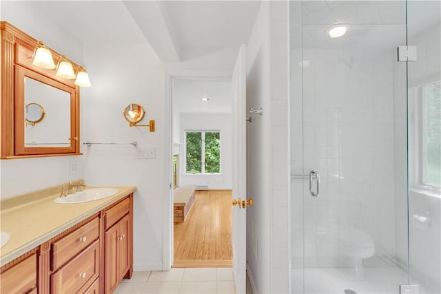 bathroom featuring tile patterned floors, vanity, and a shower with door