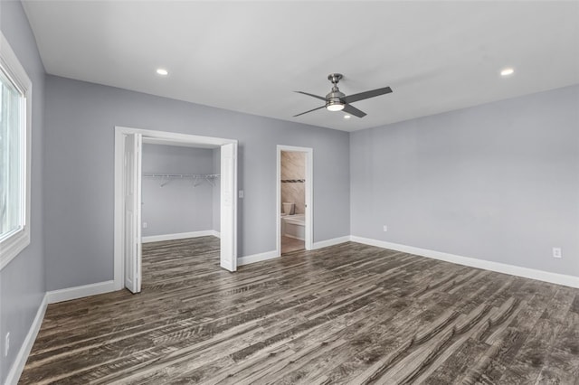 unfurnished bedroom featuring ensuite bathroom, a closet, ceiling fan, and dark hardwood / wood-style floors