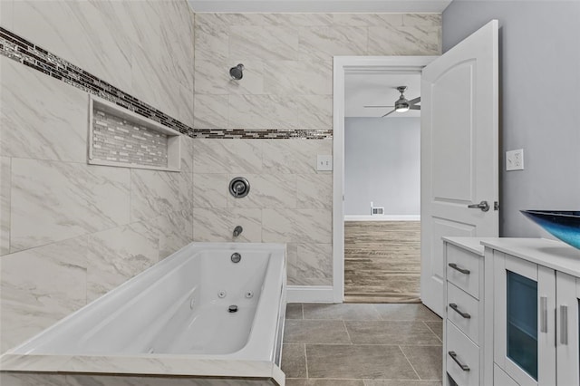 bathroom featuring ceiling fan, tile patterned flooring, vanity, and tiled shower / bath