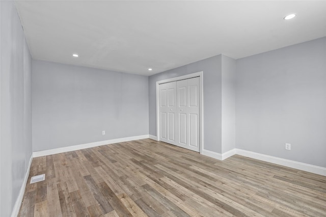 unfurnished bedroom with a closet and light hardwood / wood-style flooring