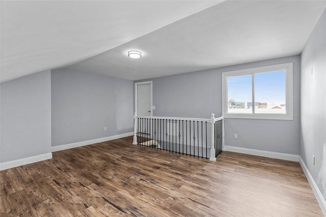 bonus room featuring dark wood-type flooring and vaulted ceiling