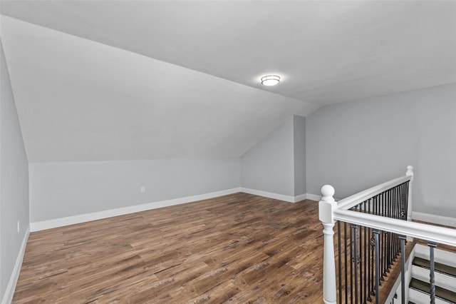 additional living space with vaulted ceiling and wood-type flooring