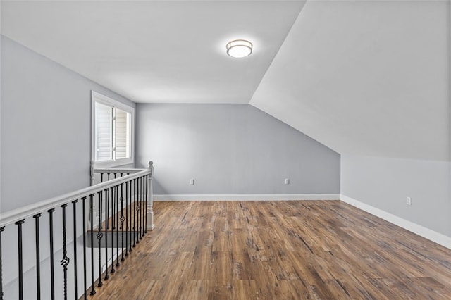 bonus room with hardwood / wood-style floors and vaulted ceiling