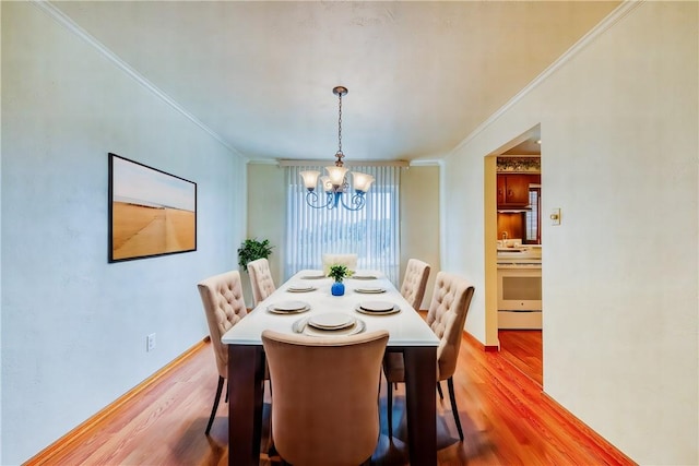 dining space with a chandelier, crown molding, and light hardwood / wood-style flooring