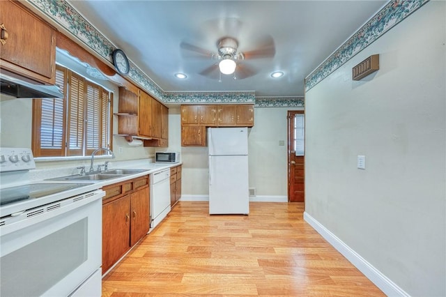 kitchen featuring ceiling fan, white appliances, sink, and light hardwood / wood-style flooring