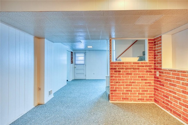 basement with carpet floors and wood walls