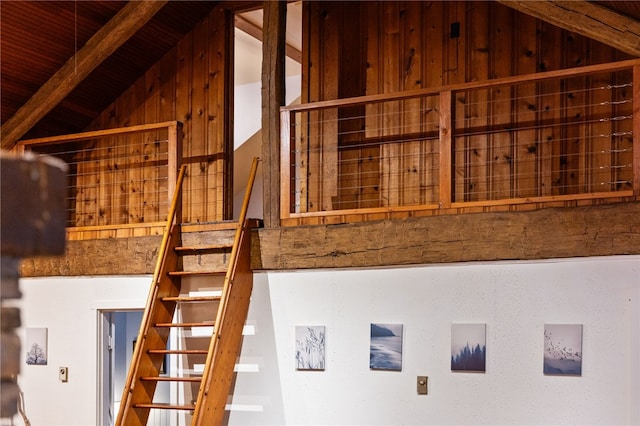 stairway with wooden ceiling and vaulted ceiling with beams