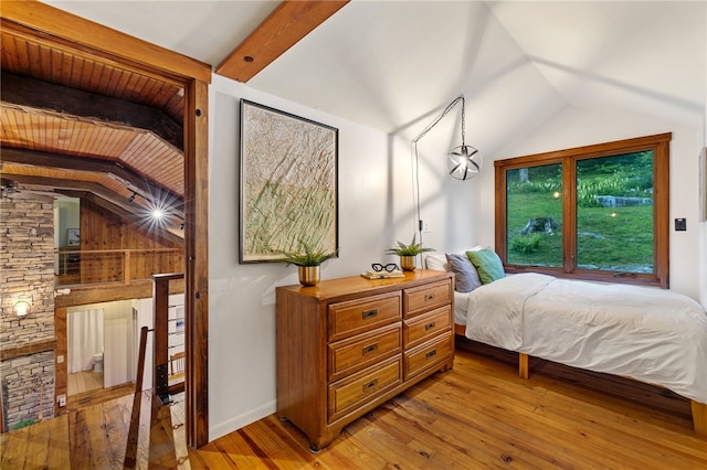 bedroom with hardwood / wood-style floors and vaulted ceiling with beams