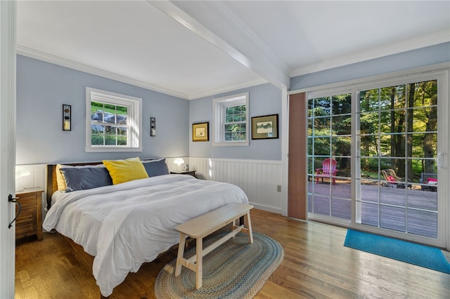 bedroom featuring wood-type flooring, ornamental molding, and beamed ceiling