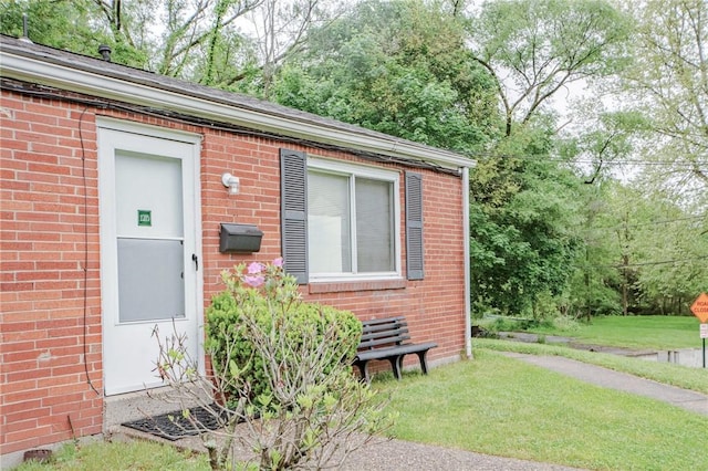 doorway to property with a lawn