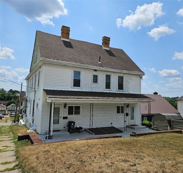 rear view of property with a patio and a yard