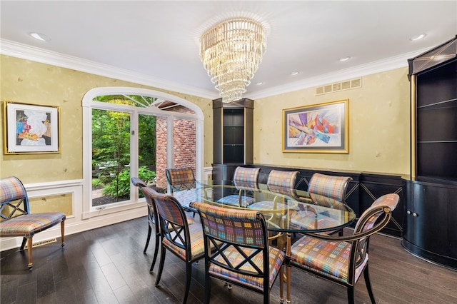 dining area with dark hardwood / wood-style floors, ornamental molding, and a chandelier