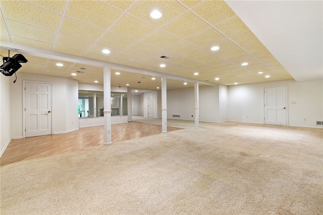 basement with carpet floors and a paneled ceiling