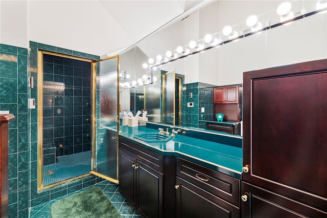 bathroom with tile patterned flooring, vanity, an enclosed shower, and tile walls